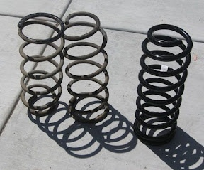 Old springs on left versus brand new OME spring on right.