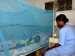 Dans la moustiquaire, un enfant victime de paludisme reçoit des soins auprès d’une infirmière à Kinshasa. Radio Okapi/ Ph. John Bompengo