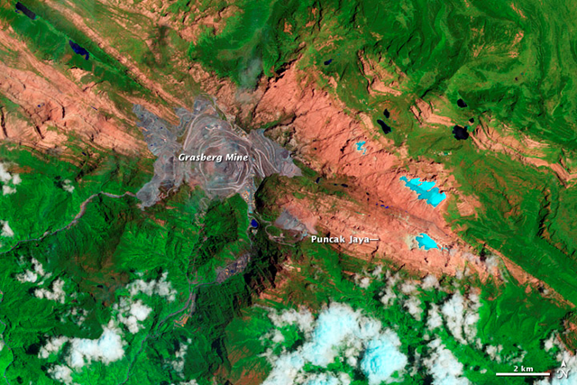 This image, captured by Landsat IV and Landsat V, shows Indonesia's tropical glaciers in 2009 on the slopes of Puncak Jaya, a 4,884-meter (1,620-foot) peak within the Sudirman Range. By 2009, two of the glaciers — Meren and Southwall — were gone. The other three—Carstenz, East Northwall Firn, and West North Wall Firn—had retreated dramatically. The gray area near the center of the image is the Grasberg gold and copper mine, established in 1990 by Freeport McMoran. NASA image created by Jesse Allen and Robert Simmon