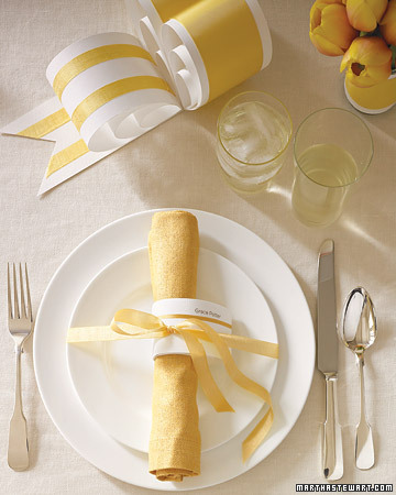 At each seat, a 3-inch paper teardrop bearing a guest's name and embellished with a tiny yellow strand of ribbon serves as both napkin ring and place card. (marthastewartweddings.com)