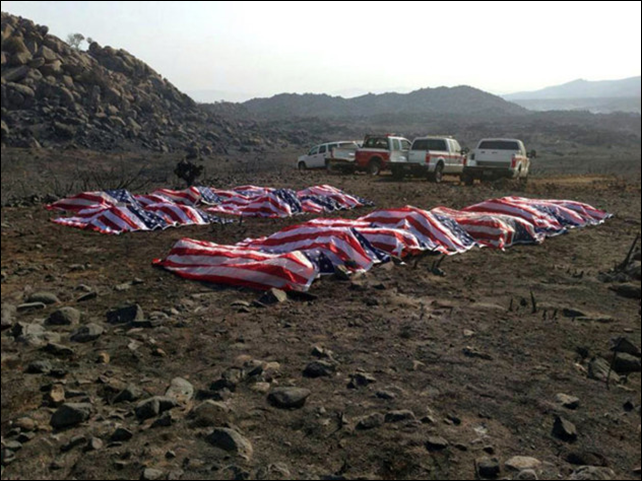This photo that appeared anonymously on Facebook on Thursday, 4 July 2013, shows what officials confirmed to The Associated Press, as the 19 dead firefighters draped in American flags by Yavapai County Sheriff Scott Mascher, shortly after they were found dead near Prescott, Ariz., on 30 June 2013. Several media outlets, including the Arizona Republic and USA Today, published the photo on Friday, 5 July 2013. Nineteen members of the Granite Mountain Hotshot crew died Sunday, 30 June 2013 fighting the Yarnell Hills Fire, about 40 miles southwest of Prescott. Photo: AP