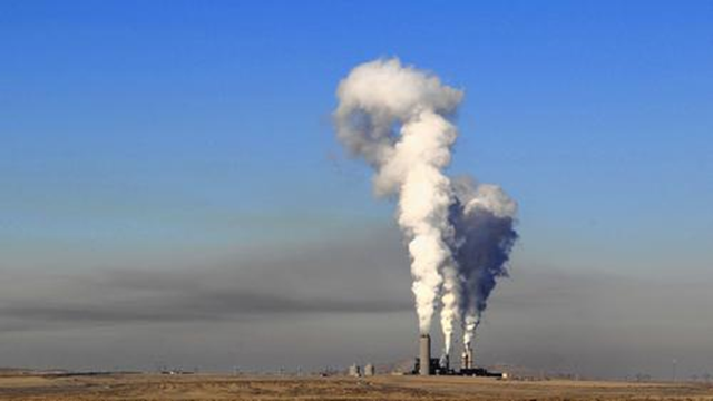 A layer of haze looms west of the Four Corners Generating Station in New Mexico. Southern California Edison recently sold its stake in the power plant, but the facility still burns coal to produce power that goes to Arizona customers instead. Photo: Josh Stephenson / Durango Herald