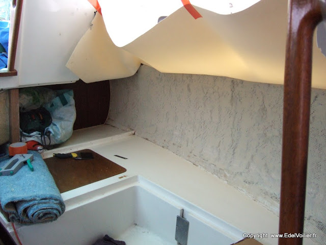 La pose du vaigrage doit se faire d'abord à blanc (mise en place sans colle). Le vaigrage est fixé avec des agrafes inox (sur la partie haute). On le maintient en l'air avec du scotch (orange) et ensuite on applique la colle à la spatule. On attend 10 minutes avant application du vaigrage (en fonction de la colle utilisée). Et on termine par chasser les bulles d'air au rouleau débulleur.