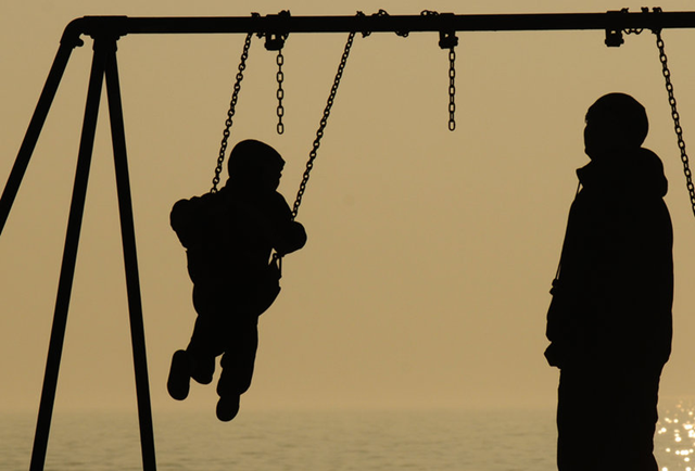 A family enjoys mild weather on the Lake Michigan shore earlier this month. A poll released Tuesday, 28 February 2012 that found more people believe in global warming was taken before the mild winter began. Don Campbell / AP Photo / The Herald-Palladium