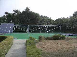 Ground Mount rack is finished and panel sections are being assembled and attached to rack. To the right is the staging area, this is where the panels were arranged, rails placed and secured to the underside of the panels (panels were placed upside down so rails could be attached).  Only the upper and lower panels were bolted at this time, the middle rows were removed  and panels were carried using rails like a "medical stretcher"! Rails were cut to length after all of the panels ahd been mounted.