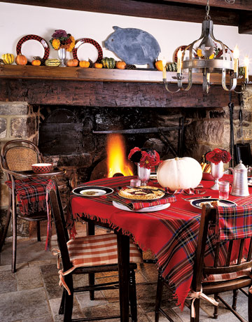 Using a simple red-tartan shawl as a tablecloth can transform the look of a tabletop. (Photograph from Country Living)