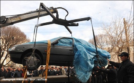 The car belonging to Iranian nuclear scientist Mostafa Ahmadi-Roshan is lifted at the site of an explosion outside a university in northern Tehran
