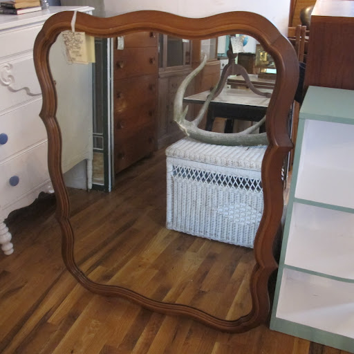 A voluptuous wooden mirror frame; notice the antler in its reflection that I considered glittering for my Halloween centerpiece.
