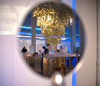 A reflected image of the chandelier, golden bars, and ice sculptures.