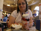 Christina holding a banana split and a berry sundae at the Ghirardelli shop.