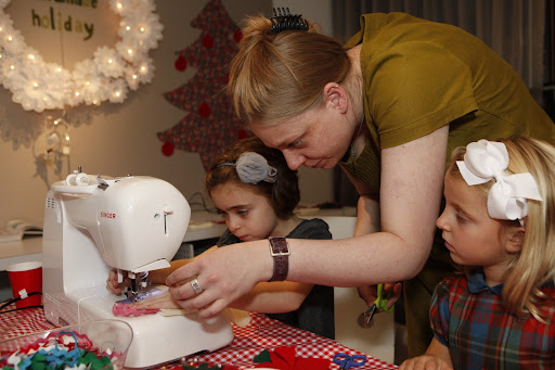 Darcy's daughter Ella, who has been taking sewing lessons, is shown here sewing her own felt bag with Andrea from Pins & Needles.