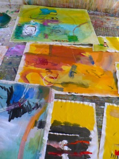 Completed paintings are laid on the floor of Booth's studio.