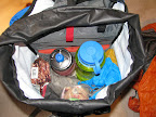 Tent wadded up. Instant dinner, electrolyte drink, water bottle, wind/rain shell, ziplock container of oatmean and hot chocolate packs.