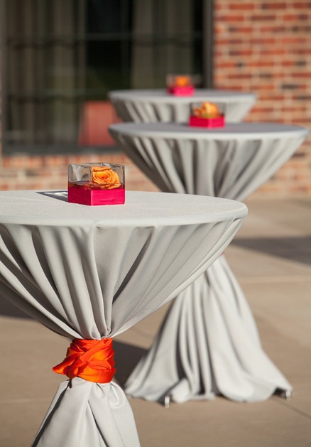 outdoor cocktail tables were covered in a gray tablecloth and tied ...