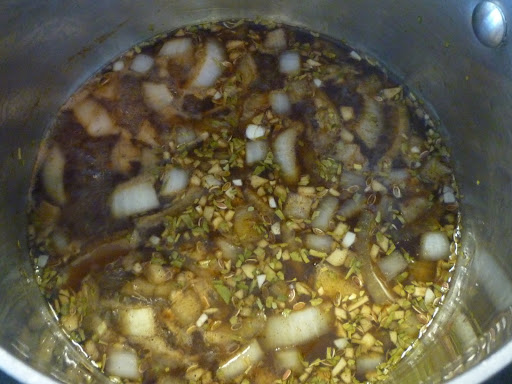 Spices, herbs, and seeds  simmer in the pan with the vinegar, onion, and garlic.