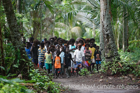 more infos : http://carterets.info - Der Kreuzweg auf Han Island. Die meisten Bewohner sind fromme Katholiken. Erste Klimafluechtlinge: Das gesamte Carteret Atoll wird aufgrund der Erwaermung des Meeres als erste Inselgruppe versinken. Alle sechs Inseln werden bis 2015 komplett vom Pazifik verschlungen sein. Hauptgrund: Das Abschmelzen der Gletscher und Eisberge. Die Carteret Inseln waren traumhaft schoene Refugien. Weisse Sandstraende umsaeumten einst die Kuesten des Atolls. Oberhalb der Straende reckten sich majestetische Palmen gen Himmel und spiegelten sich bei ruhiger See im tuerkisblauen Wasser des Pazifik. Die Palmen liegen heute umgestuerzt in einem Meer aus Schlamm. Die Straende sind bereits versunken. Ende 2008 soll die Umsiedlung beginnen. Die Inselbewohner kaempfen um ihre Inseln.