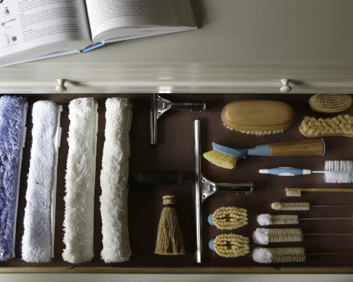 A collection of squeegee sleeves, squeegees and brushes for any household chore.  Laying items flat like this in drawers makes them easy to find.