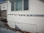 Holes Drilled into a course of siding awaiting insulation