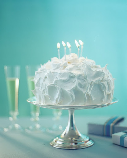 A silver stand has a glow when it features a white dessert on it's surface.
