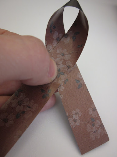 The first step in making the bow is folding one of the longest strips in half like this.
