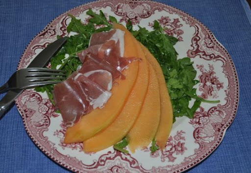 Cantaloupe and prosciutto over arugula