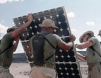 U.S. marines build a solar panel. For several years, the view that global warming caused by burning fossil fuels is an overwhelming national security threat has been taking firmer hold in national security circles. Photo: U.S. Department of Defense