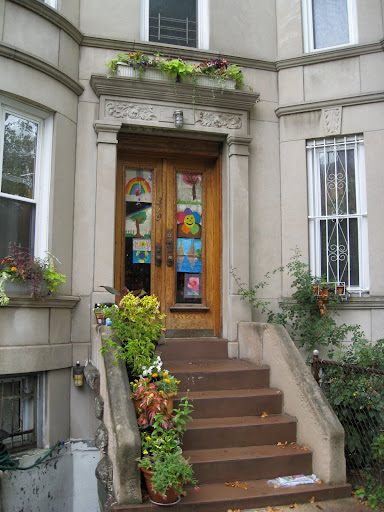No front yard is no deterrent for these residents! They've got plants just about anywhere they could hang them. I love the way the children's drawings add to the colorful, happy effect.