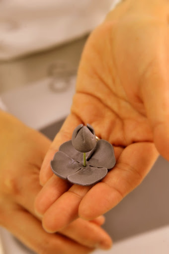 Ana threads the delicate petals onto the stem.