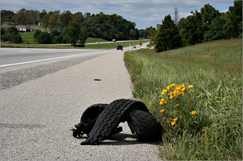 c0 Tire treads alongside a highway.