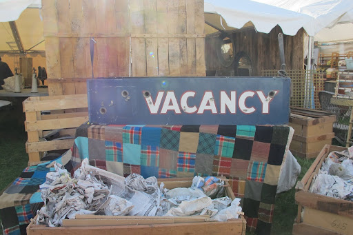 A hotel sign rests on a patchwork blanket.