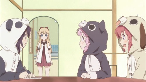 A scene where three of the girls sit at the table wearing kigurumi, or animal-themed pajama suits