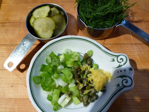 Scallions, capers, lemon zest, pickle slices, and dill are ready for the food processor.