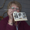 Gloria Hanke looking at a photo of senior class officers:  Jim Roberts, Gloria Hanke, Bob Hodgson, Don McDowell