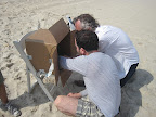 Daniel and James look at the photos on a laptop guarded from the sun by a very high-tech shield also known as a cardboard box.