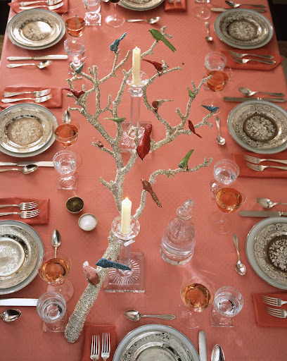 Birds alight onto a tinsel-wrapped tree branch, which is used as a centerpiece. Birds alight onto a tinsel-wrapped tree branch, which is used as a centerpiece.