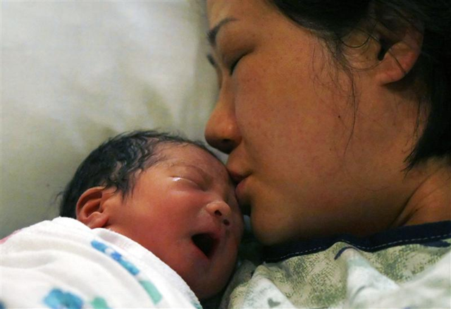 Baby Cin gets a kiss from his mother Miran shortly after being born at Avista Adventist hospital in Louisville, Colorado near Denver at 2:41 a.m. local time on 31 October 2011. Rick Wilking / REUTERS