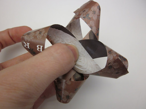 You keep making figure eights and stacking them, getting smaller as you go, sticking each layer with a little glue or double-sided tape.