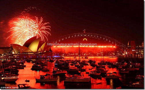 A red hue lights up the sky over the Sydney Opera House. More than a million people gathered to watch and then celebrate 2012