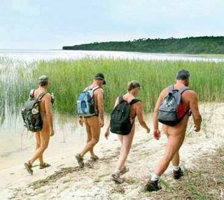Escursionismo gruppo nudista (dietro) lungo spiaggia Escursionismo gruppo nudista (dietro) lungo spiaggia