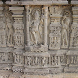 Who it could be, in central niche, shown carrying vajra, khadga and perhaps a khetka. There is one person shown lying near his feet at the base of the niche. There is a prabha-valaya behind his head. It seems that this prabha-valaya is made of several serpent hoods.