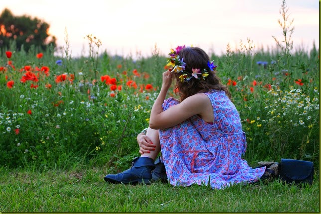 girl sitting in wild flowers girl in wild flower field