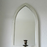 Gothic type wooden mirror with candle sconce in a bronze coloured metal