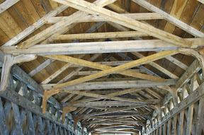 Wedged cross bracing helps stiffen bridge laterally.