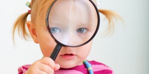 Toddler girl looking through magnifier