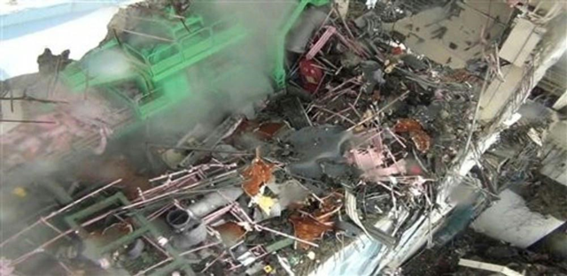 This Thursday, 24 March 2011, photo shows the inside of Unit 4 at the Fukushima Dai-ichi nuclear power plant in Okumamachi, northeastern Japan. Steam comes out of debris by a crane device, in green, at the unit. Photo: TEPCO