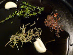 Garlic, herbs, and hot pepper gently infusing oil with flavor.