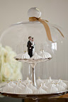 A mini couple standing among dainty meringues at the dessert table. A mini couple standing among dainty meringues at the dessert table.