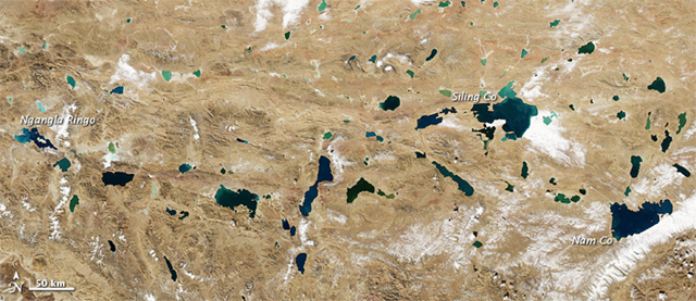 The Moderate Resolution Imaging Spectroradiometer (MODIS) on NASA’s Aqua satellite captured this natural-color image of the Tibetan Plateau on 10 November 2010. Resembling bits of abalone shell, the lakes glimmer in assorted jewel tones. NASA Earth Observatory image created by Jesse Allen, using data obtained from the Goddard Level 1 and Atmospheric Archive and Distribution System (LAADS)