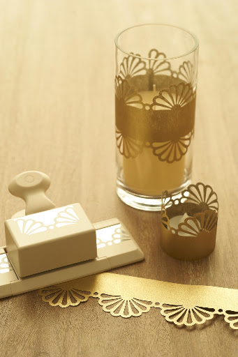Gorgeous cylinders from Save-on-Crafts.com create simple decor for your table. Punch your paper and place around each cylinder. You can also attach your punched paper to pillar candles with a piece of double stick tape. (Gold paper for cylinders, napkin rings, and votive wraps from http://www.paper-source.com/)