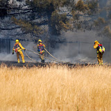 South Sacramento Homes Nearly Burned, July 5, Sacramento, CA by Ed Fogle <BR> Sacramento Firefighters save homes from a fast moving grass fire today in South Sacramento. Witnesses state that juveniles were playing with fireworks which landed in the dry field and burned more than 2 acres then burned through the back fence of the homes adjacent to the field. Sacramento Firefighters attacked the fire aggresively from both the 44th street side and Lang Ave. The fire skirted the property of a church on Lang Ave. that spans the block from Lang back to 44th. The church had a good asphalt border around which protected the church from the fire. Grass Fire, 44th near 47th, Sacramento, CA